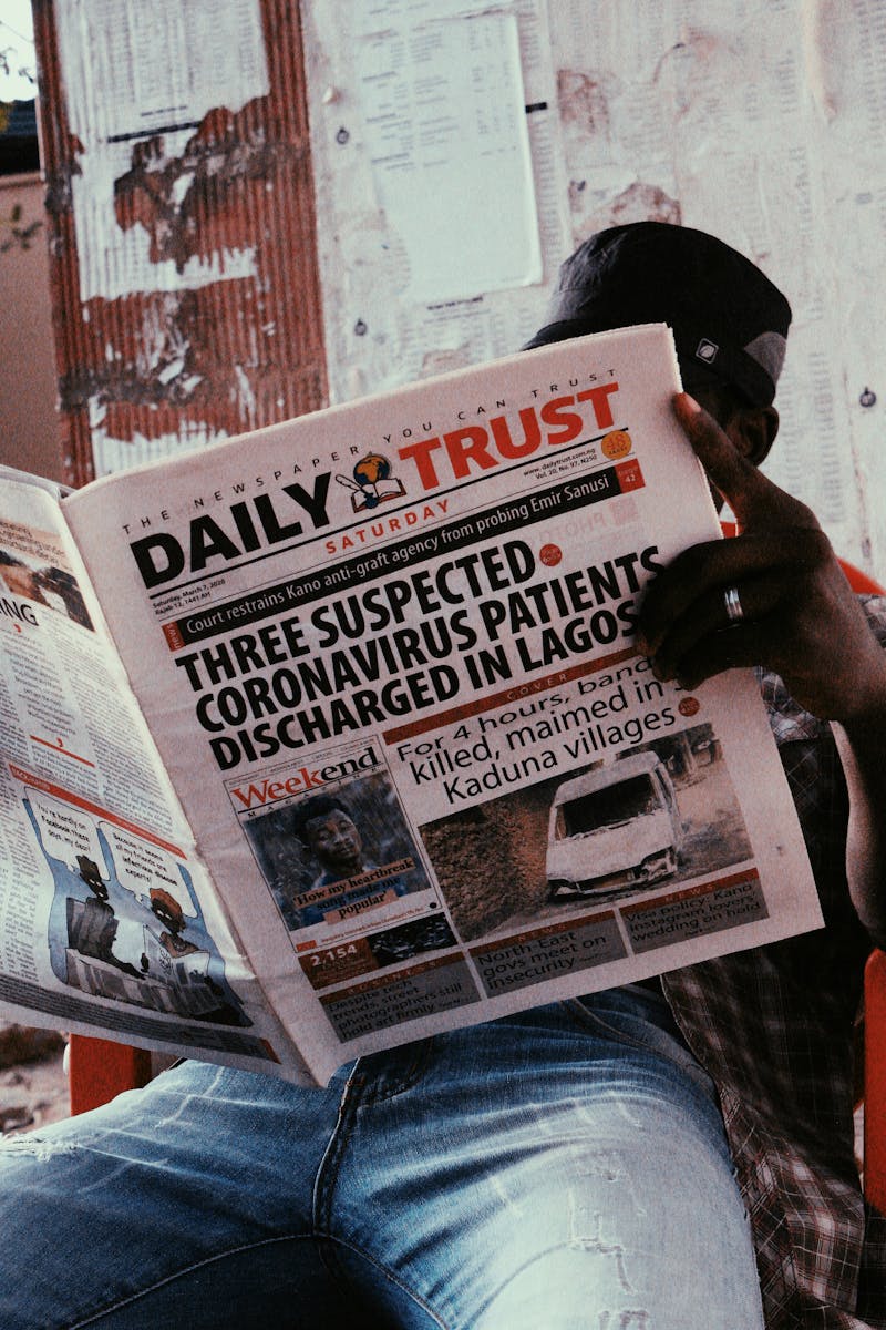 A Man Sitting and Reading a Newspaper